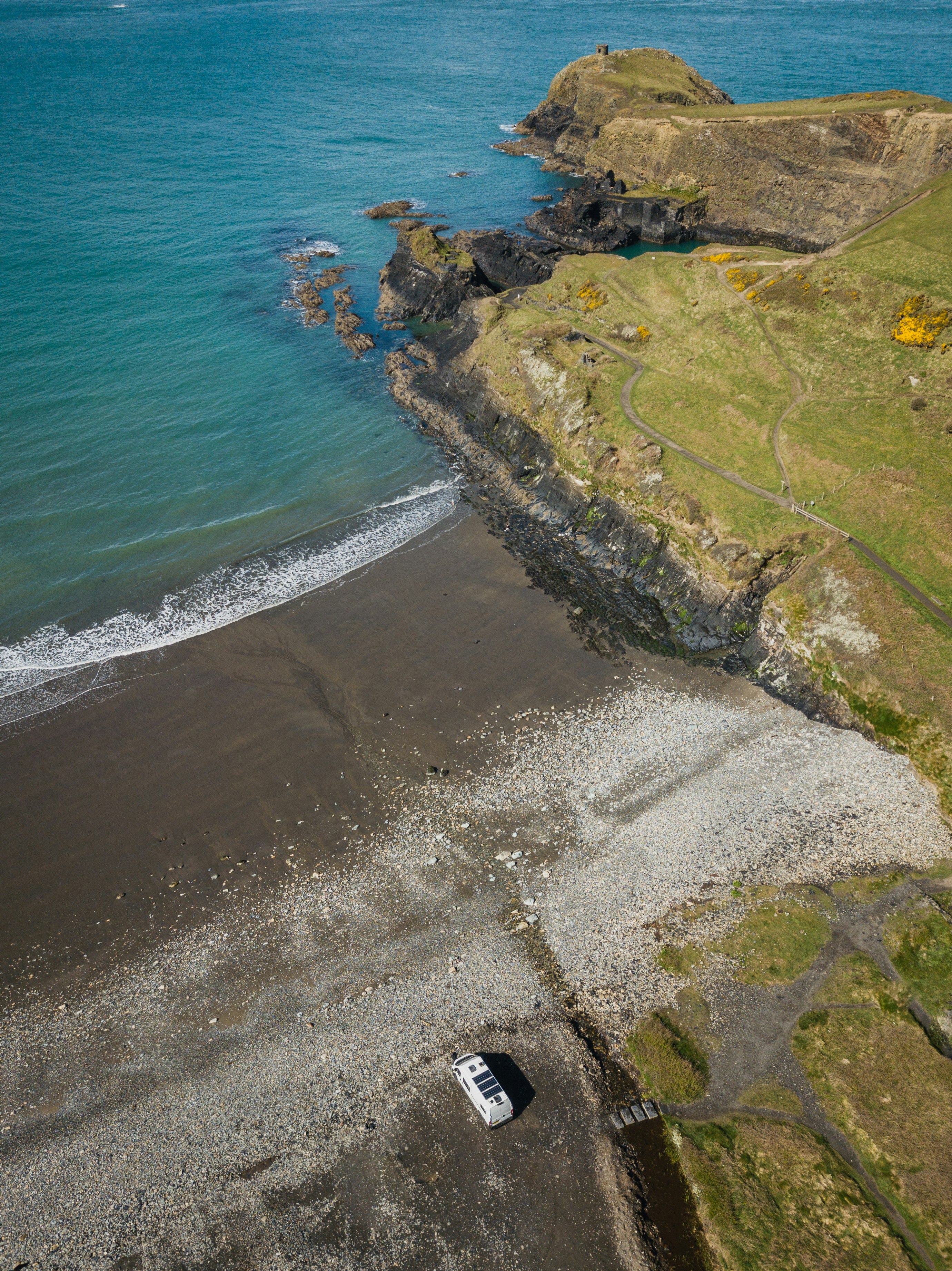 aerial view of green grass field beside body of water during daytime